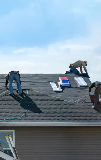 Roofers working on a shingle roof